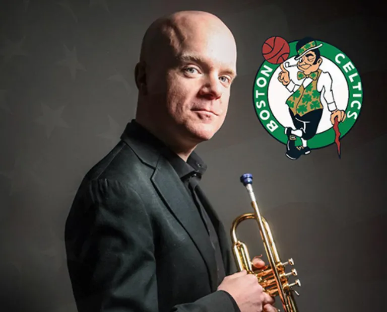 photo of bald man in a suit holding a trumpet